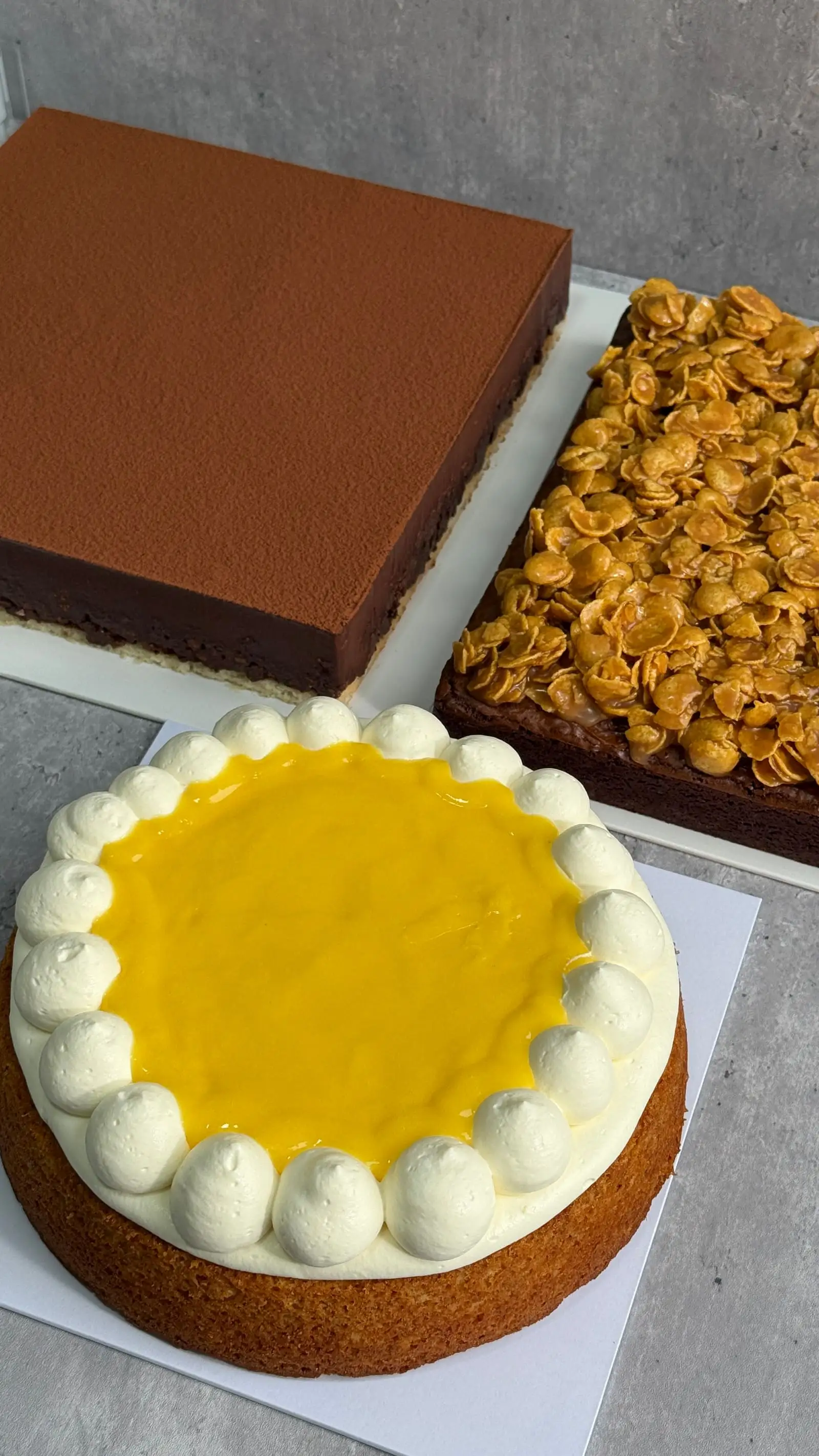 Assorted custom celebration cakes with different colours, sizes, and piped details.